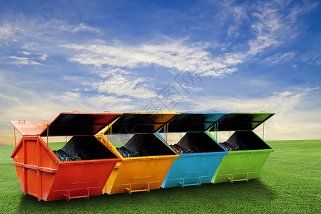 绿草蓝天背景下用于城市垃圾或工业垃圾的彩色工业垃圾箱图片