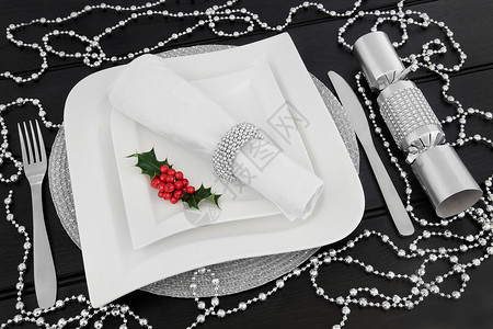圣诞晚宴桌布满白瓷板冬瓜餐具餐巾纸戒指和银珠饰品图片