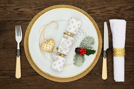 圣诞生活桌摆放着白色瓷板饼干心形黄瓜古董刀和叉子餐巾和金环图片