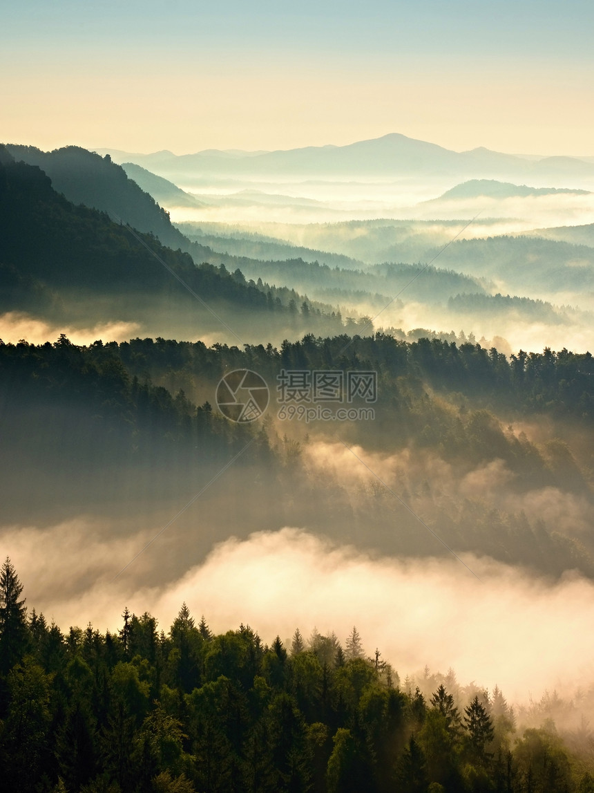 在美丽的山丘中起雾山峰从雾的本底露出一图片