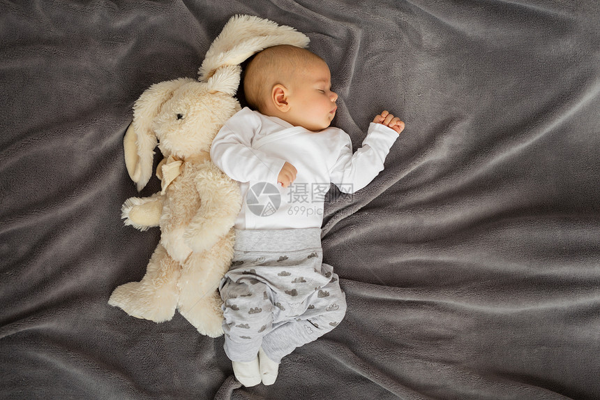 婴儿睡在毯子上的毛绒动物图片