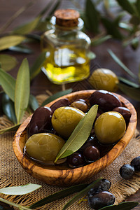 乡村木背景上的橄榄油和橄榄图片