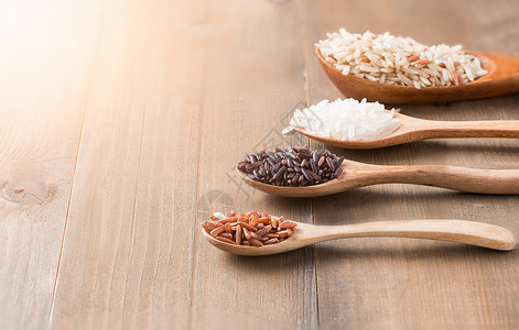 米莓糙米木勺茉莉花米生米和木头背景概念饮图片