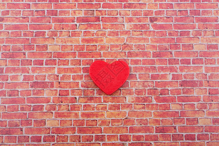 砖墙上的红色心形图标背景图片