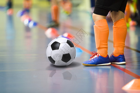 孩子们训练室内五人制足球用足球训练室内足球的小男孩穿着浅橙色运图片