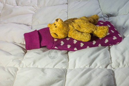 生病的概念泰迪熊躺在带热水瓶的床上图片