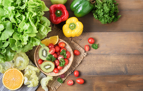 新鲜沙拉蔬菜和水果番茄甜椒欧芹木背景猕猴桃概念饮图片