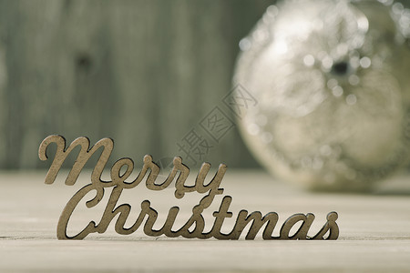 生锈木表面的文字欢乐圣诞节和背景中装饰的圣诞舞会图片