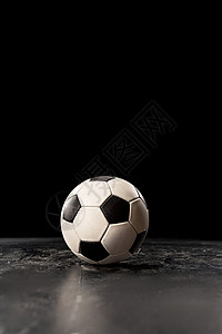 黑地板上的单个足球背景图片