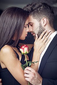 年轻男人向爱人送玫瑰在室内情侣相图片