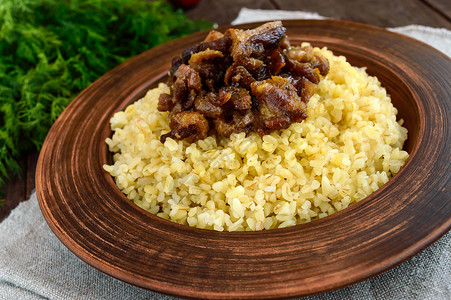 东部传统小麦粥富含烤肉深木本底粘土碗中培根的图片