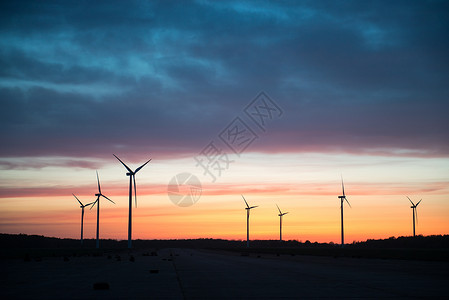 在美丽的日落剪影风力涡轮机发电站图片