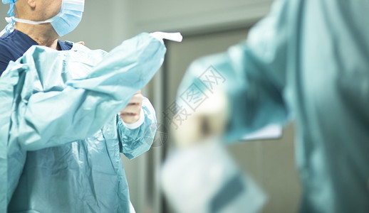 医院外科手术中的外科医生在手术室急诊室穿着无菌图片