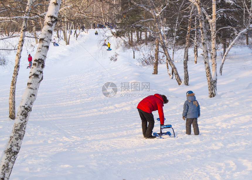 父亲帮儿子纠正雪地摩托滚下山坡图片