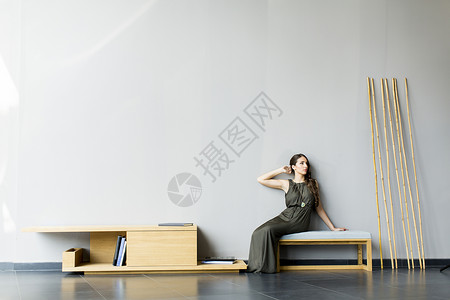 坐在灰墙边现代房间的长椅上的背景图片