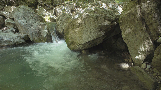 小山涧上的4K瀑布水流过石头图片
