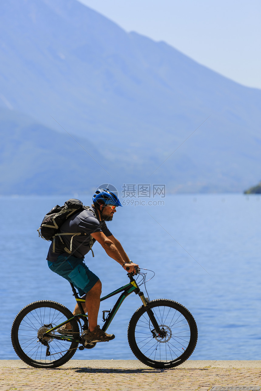 在意大利RivadelGarda的SentierodellaPonale路上骑着阳光明媚的白日男子在加尔图片