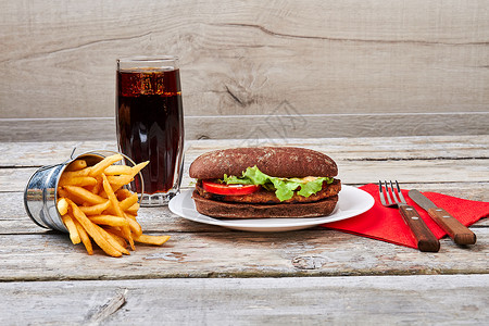 餐巾上的汉堡和餐具薯条可乐叉子和刀子图片