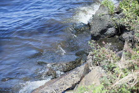 海浪在湖岸上撞击沥青的特写图片