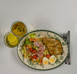 用鸡肉培根樱桃番茄鸡蛋卷心莴苣和一杯白葡萄酒酱柠檬水装饰盘子图片