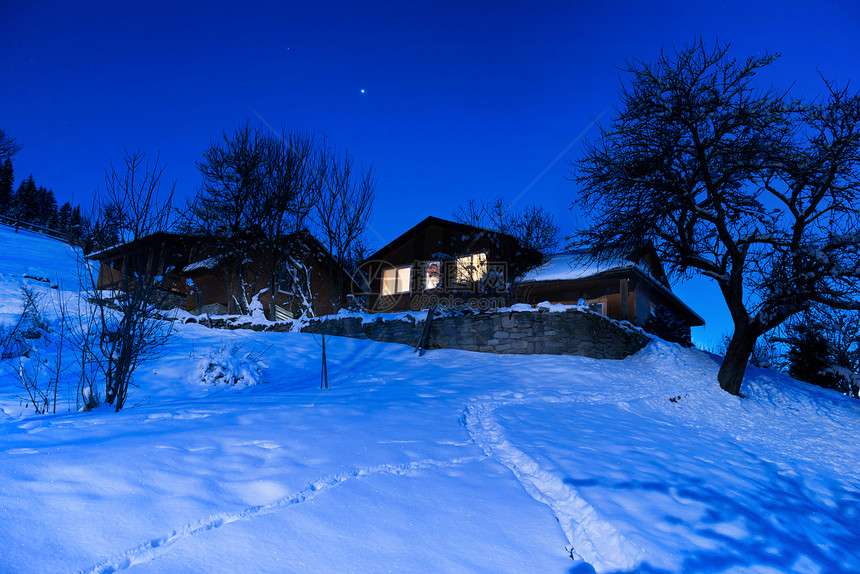 冬夜雪中的木制乡间别墅图片