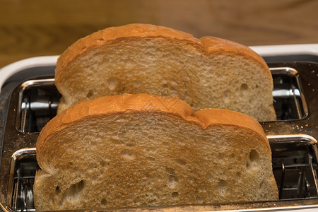 烤面包机里有两片新烤的白面包片图片