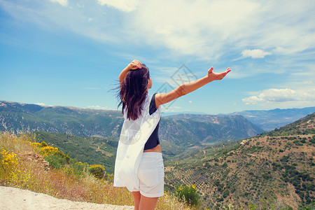 站在希腊美丽山地背景前的美丽的年轻女子图片