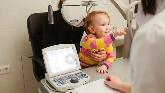 小女孩在眼科室的病人在咨询时有妈和的背景图片