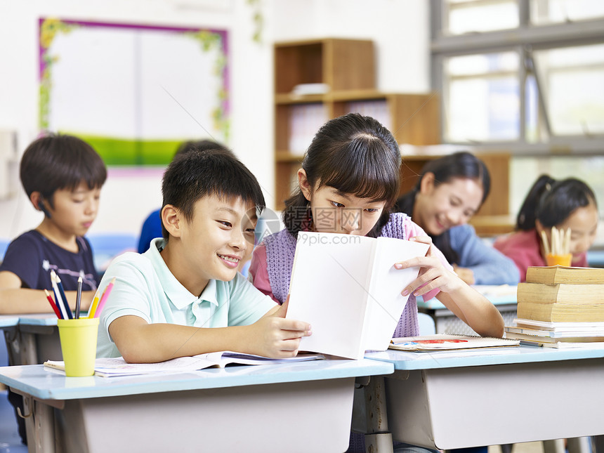 在课堂上分享一本书的女学生和男学生图片