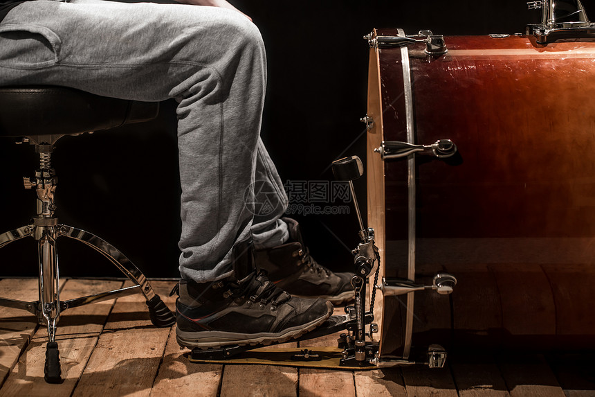 弹贝斯鼓的男子黑人背景的木板创意音乐的概念震图片