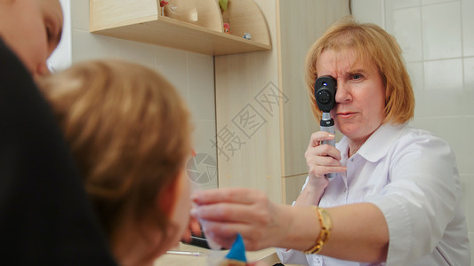 验光师检查女孩的视力母子在眼科室进背景图片