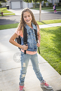 一个可爱的女学生早上背着包去上学准图片