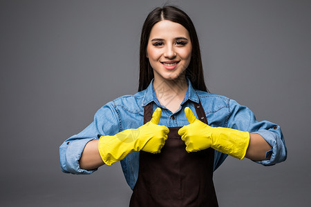戴着黄色手套的清洁女工竖起大拇指图片