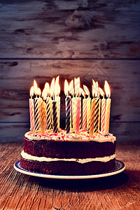 一个蛋糕上挂着一些点燃的蜡烛图片