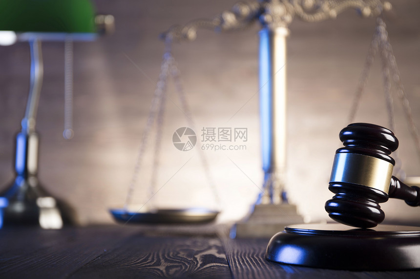 木桌上的法官和司法规模的槌图片