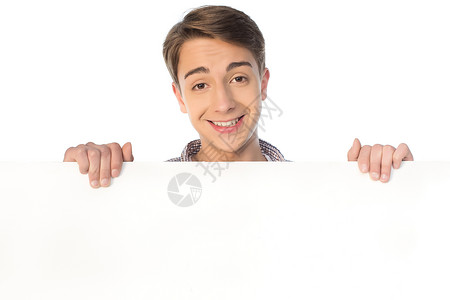 微笑的十几岁的男孩拿着空白的横幅被白色隔离图片