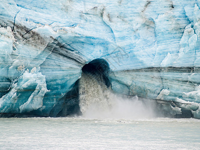 在阿拉斯加的TracyArm海湾面对冰川时从大洞中涌出背景图片