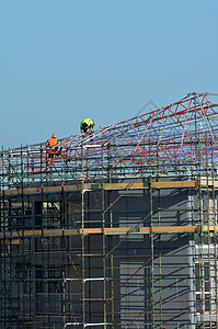 脚手架上无法辨认的建筑工人建筑建筑热潮和劳动保护概图片