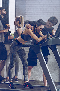 运动型年轻女运动员在健身房的跑步机上跑步图片