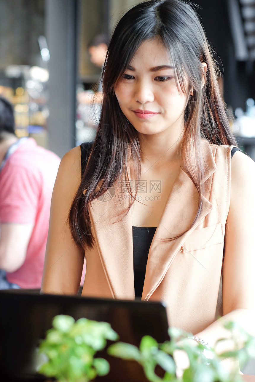 年轻的智能自由职业女商人在咖啡店用笔记本电脑图片