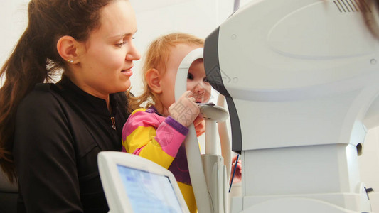 在眼科诊所使用眼科设备进行儿童检图片