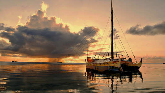 一艘传统的帆船在赛班环礁湖漂浮其背图片