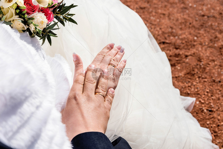 新婚夫妇手与结婚戒指的图片