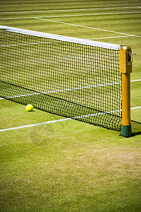 阳光下专业网球场的球赛在靠近网背景图片
