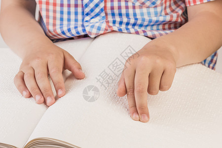 盲童正在看一本用盲文写的书用手指背景