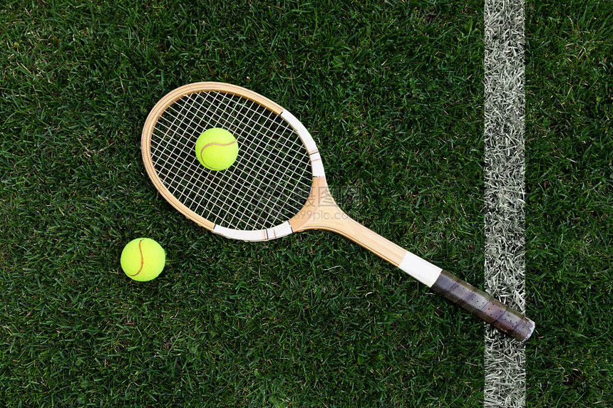 天然草地上带球的复古网球拍顶视图图片