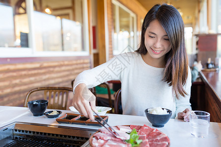 女人在日本餐厅享受烧烤图片