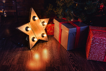 圣诞礼物在圣诞树下带灯图片