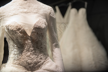 在黑暗房间展示的白球礼服或婚纱装饰刺绣花罩图片
