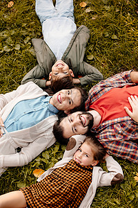 幸福家庭与两个孩子躺在草地上的图片